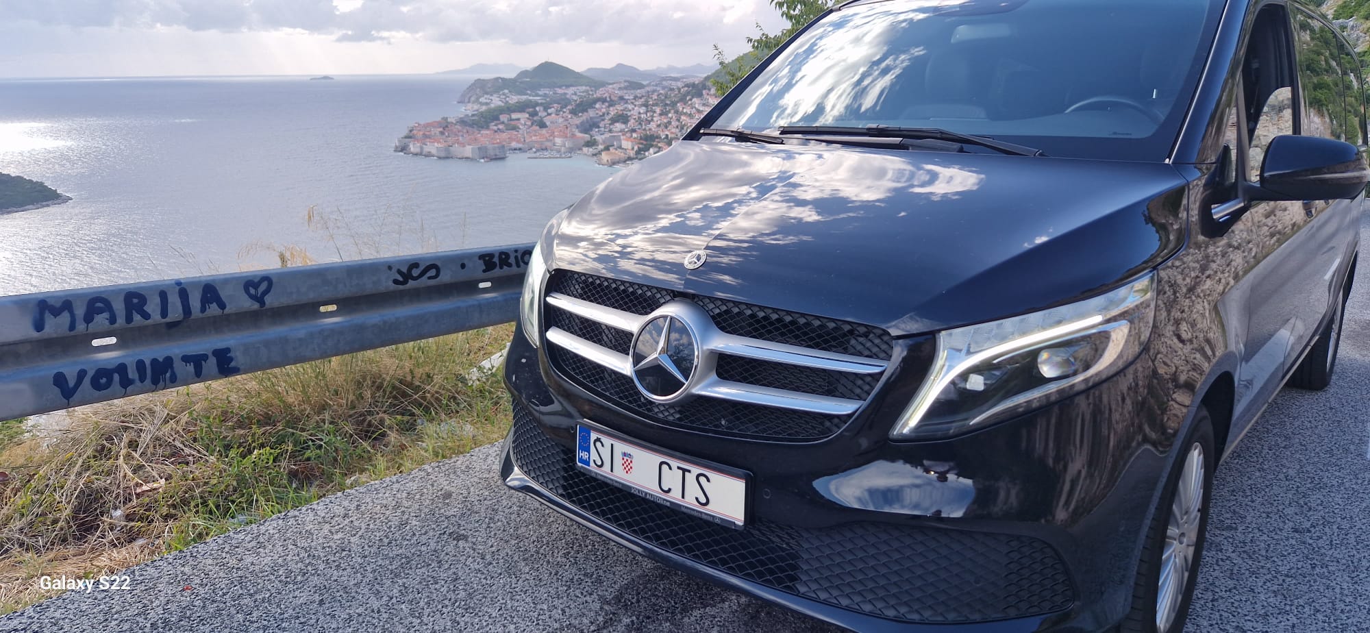 Premium Mercedes van at scenic overlook above Dubrovnik old town with red-roofed medieval architecture and Adriatic coastline